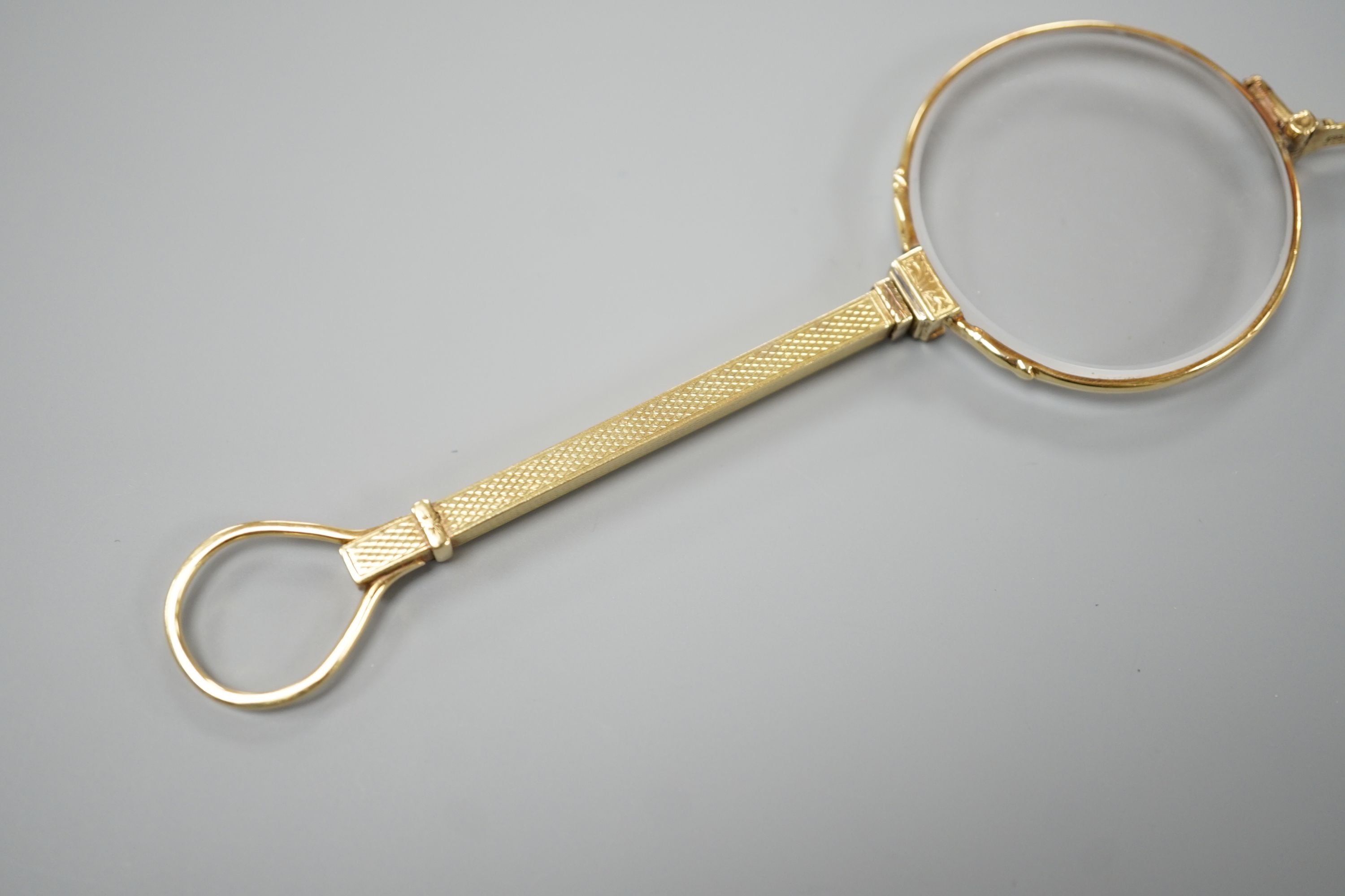 A pair of Edwardian 15ct lorgnettes, by Dixie, 20 Welbeck Street, London, with engine turned handle, 11.4cm, gross weight 28.9 grams.
